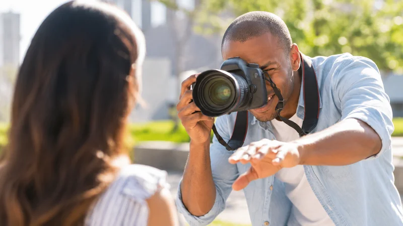 Professional dating photographer directing a man during an outdoor photo session showing expression coaching and body language guidance